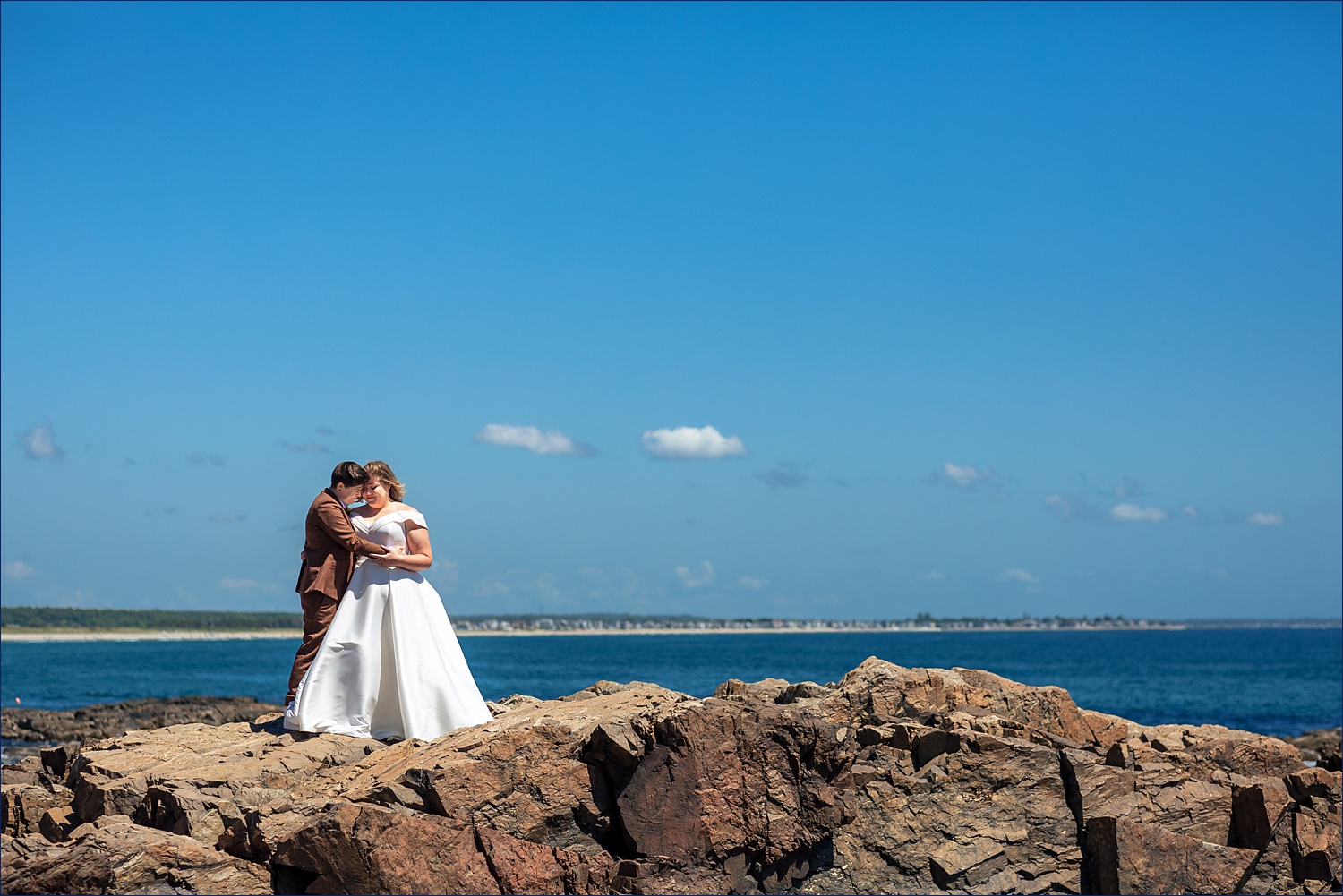 The couple stands atop the rocks on Marginal Way in Maine on their elopement day