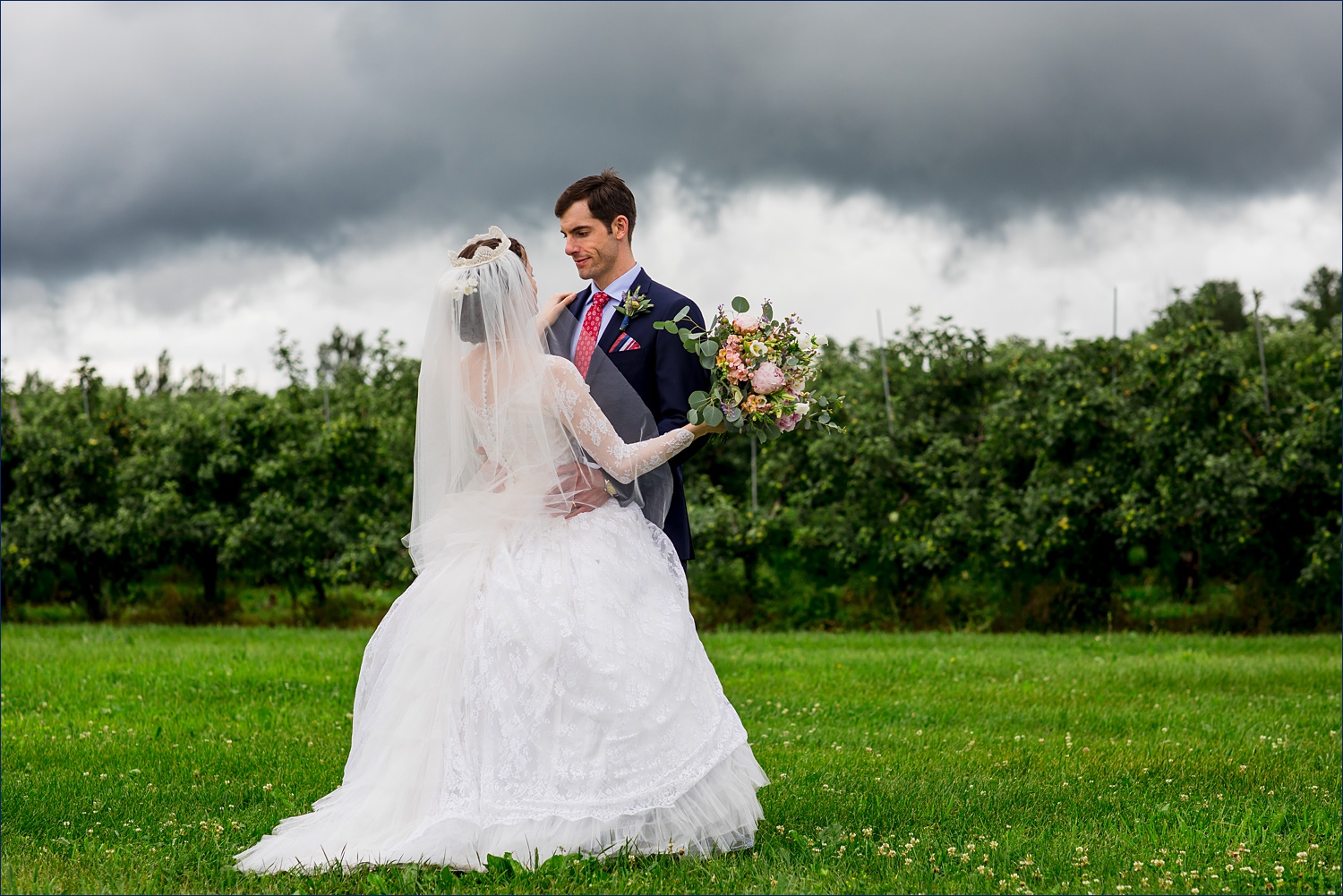 The bride and groom and a stormy sky on their wedding day in Alyson's Orchard in New Hampshire