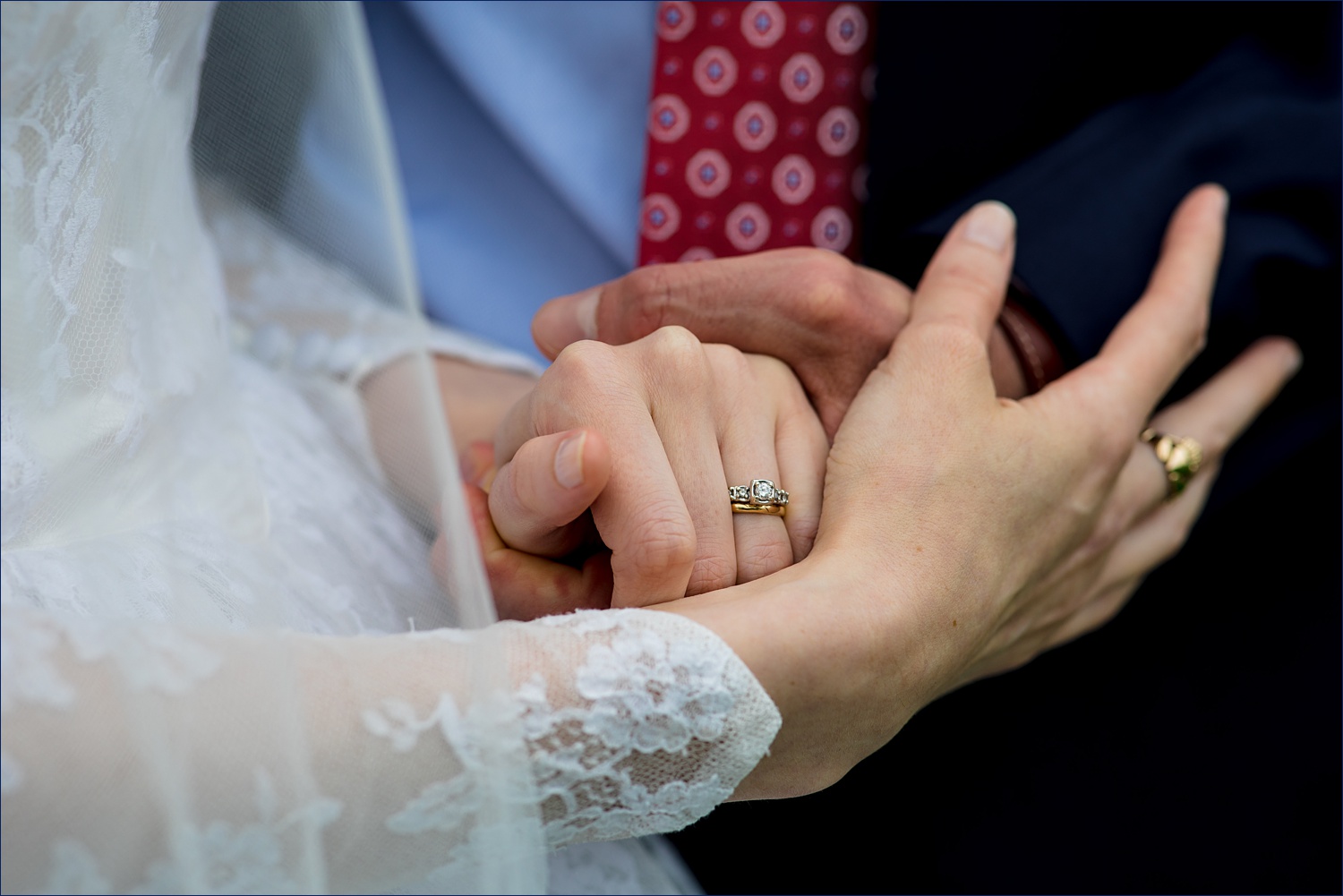 The bride and groom clasp hands together on their wedding day