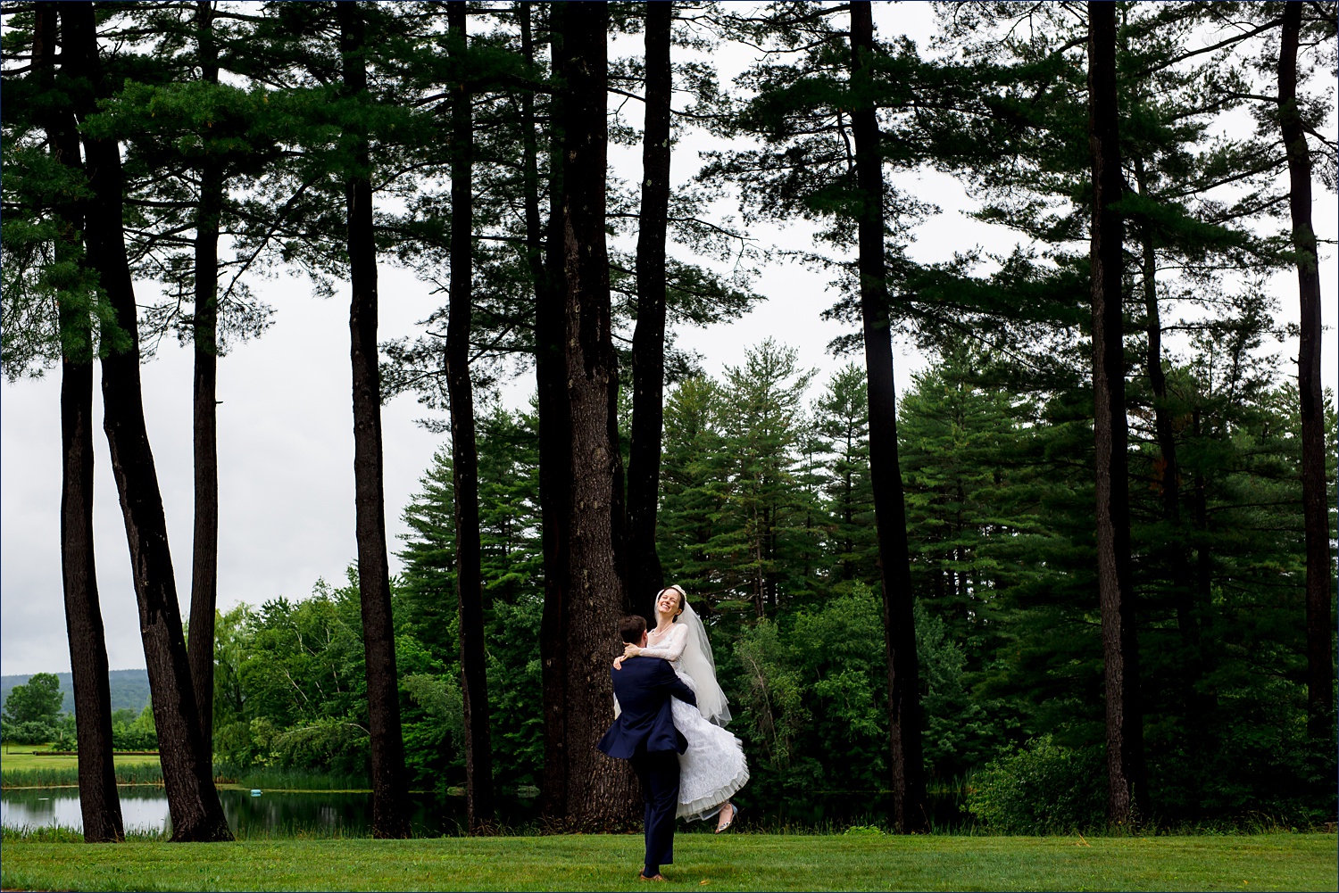 The groom picks up and spins his bride on their White Mountains New Hampshire wedding day