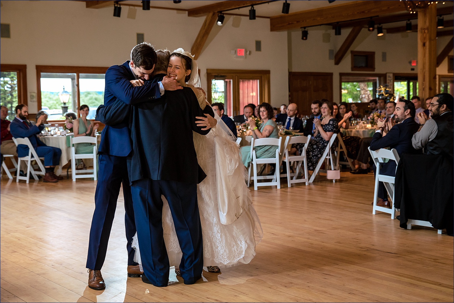 The newlyweds embrace her father on their wedding day in NH