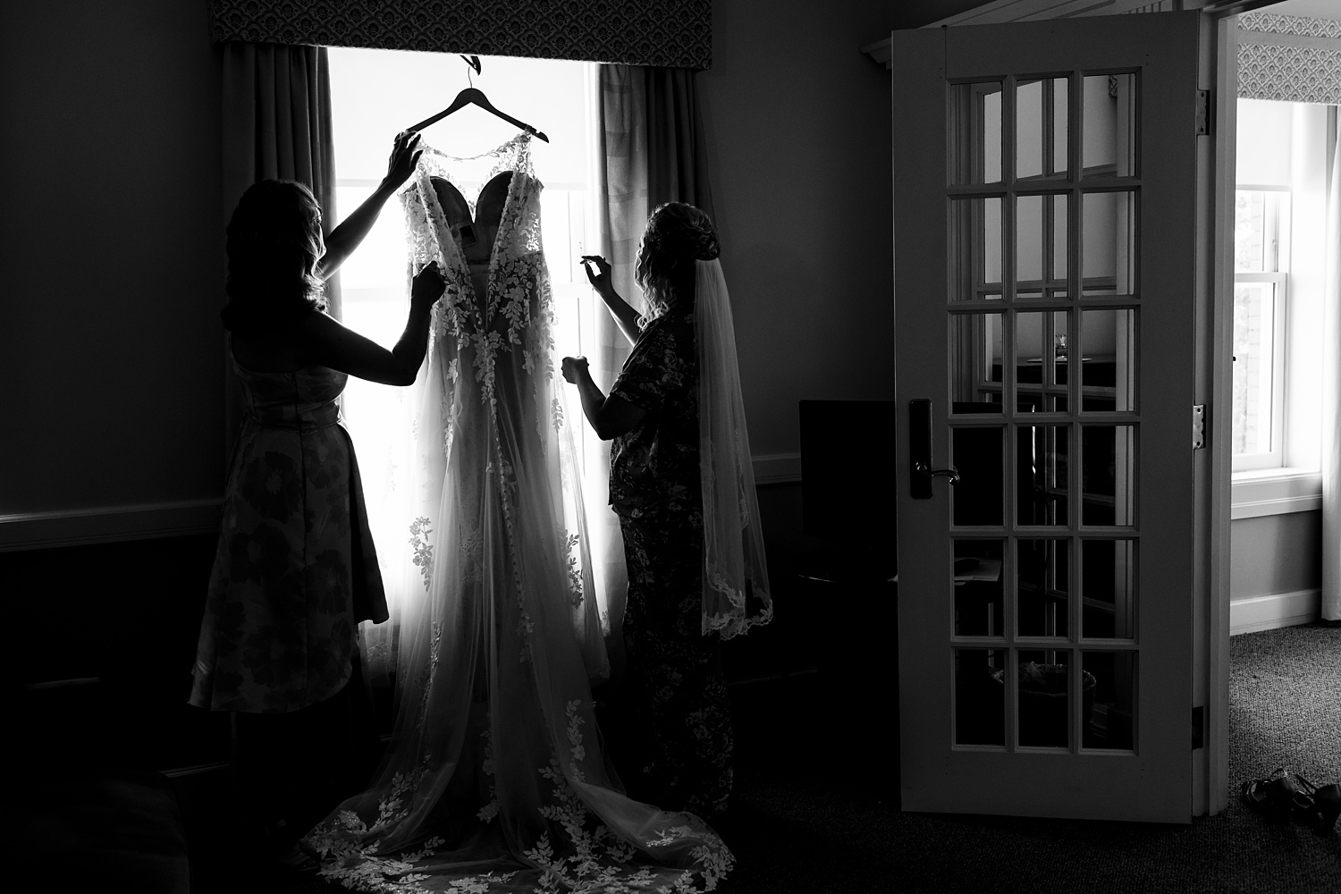 Bride and her mom get her dress ready to be put on