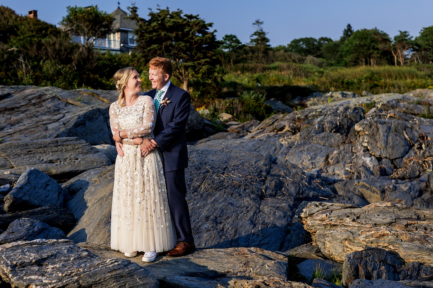 Husband and wife share a moment on the rocky cliff walk in Maine