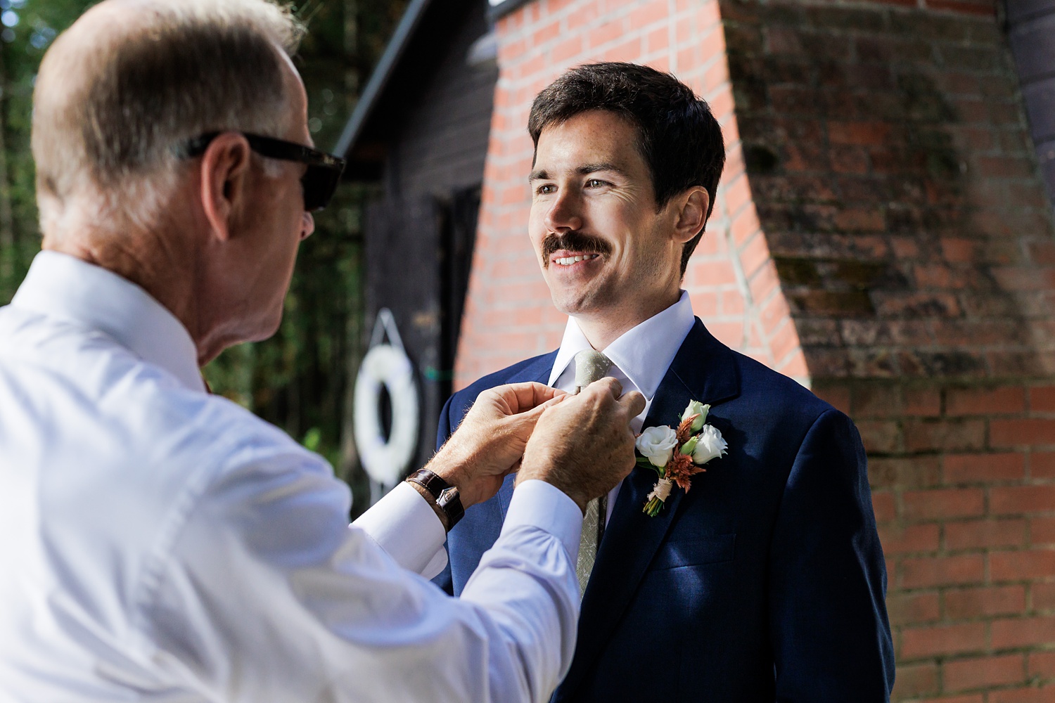 Father of the groom straightens his son's tie