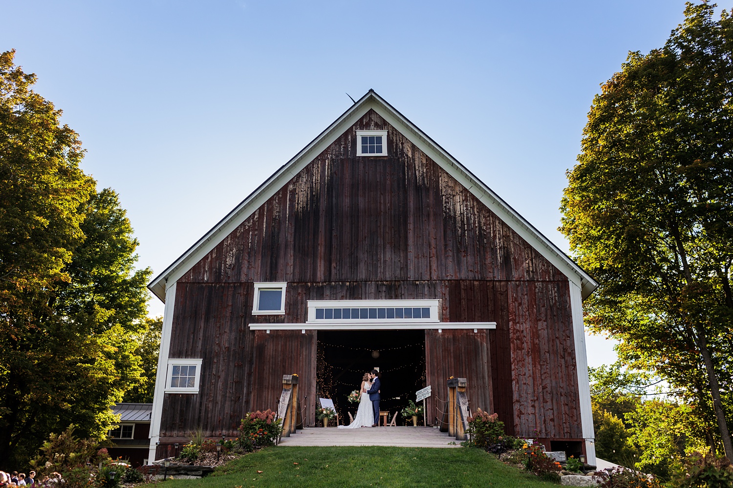 Bride and groom in front of the barn on their fall wedding day