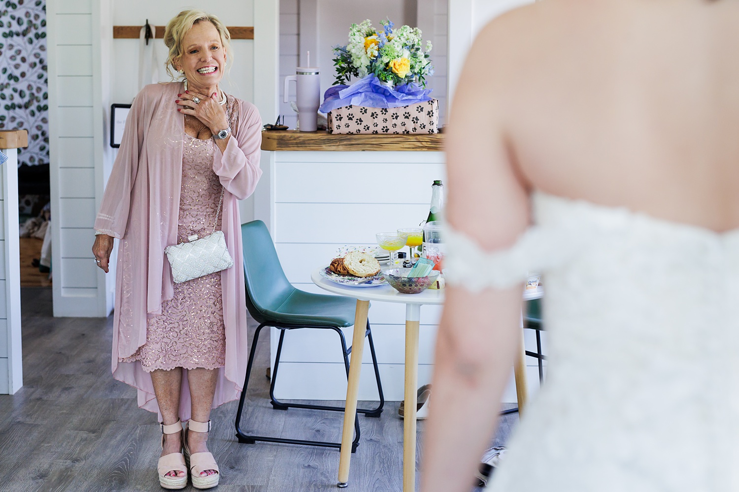 Mother of the bride smiles at her daughter in her dress