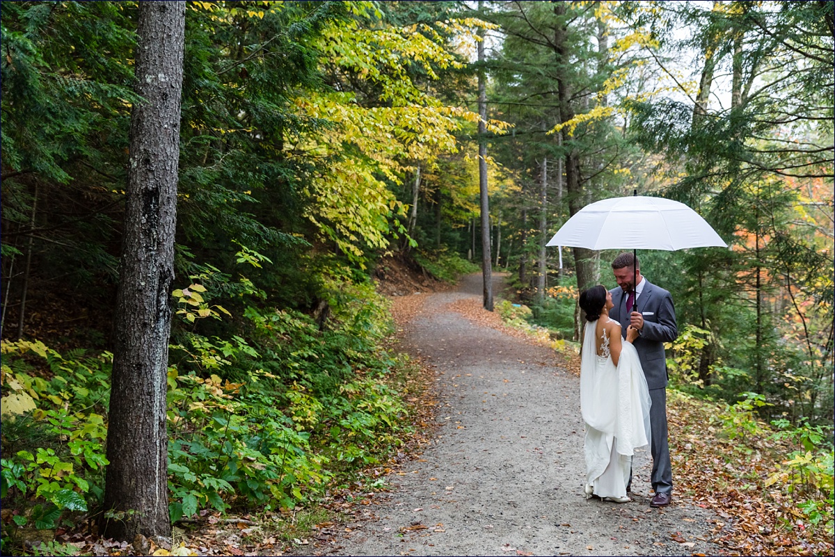Waterville Valley New Hampshire Wedding bride and groom under an umbrella during their first look out in the woods