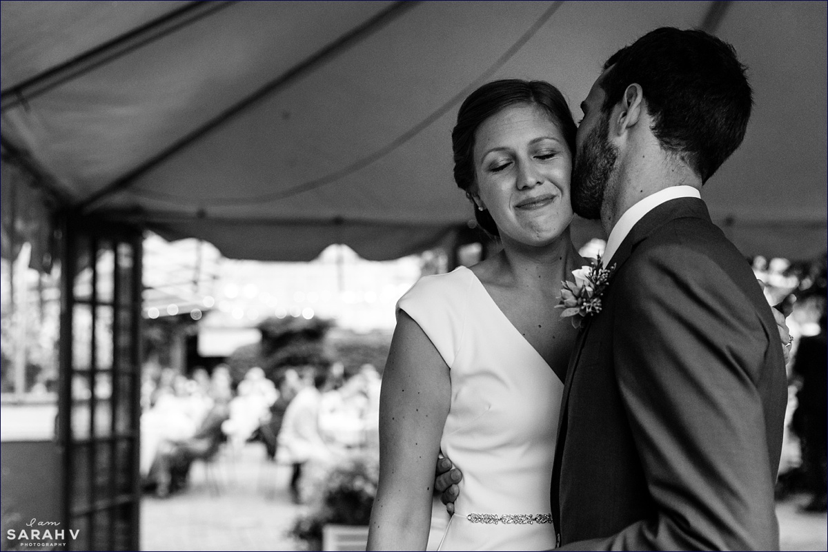 The groom kisses his bride on the cheek before they head into their greenhouse reception in New Hampshire