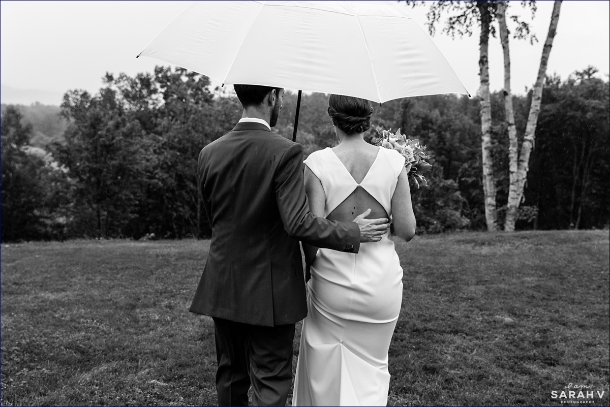 Common Man Italian Farmhouse wedding the bride and groom walk out in an umbrella after their intimate wedding at the Barn on Pemi at a NH wedding