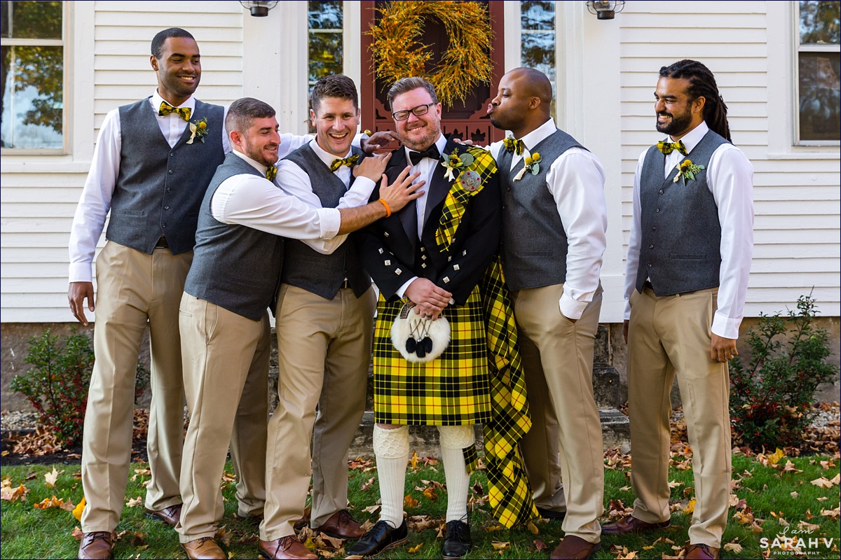 The groomsmen show some love to the groom during pictures in Southern Maine