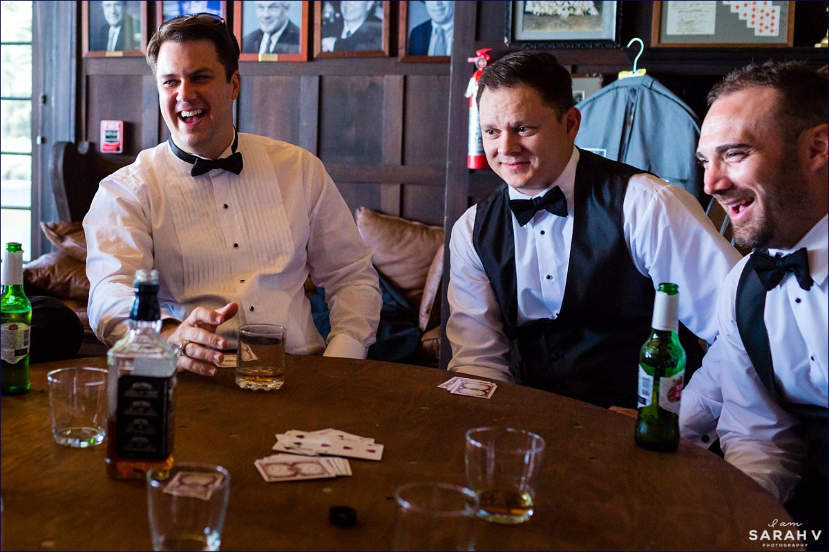 The groom and groomsmen enjoy cards and drinks inside