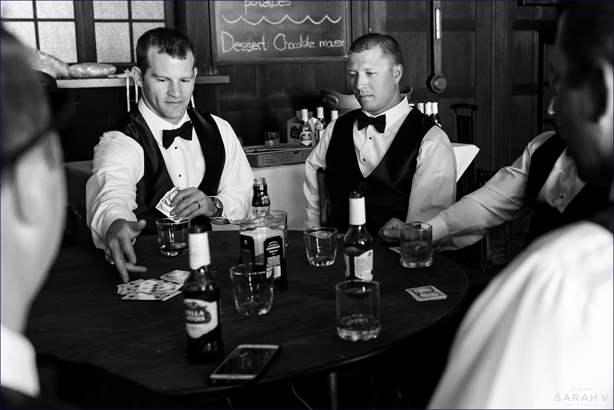 The groom and groomsmen enjoy cards and drinks inside