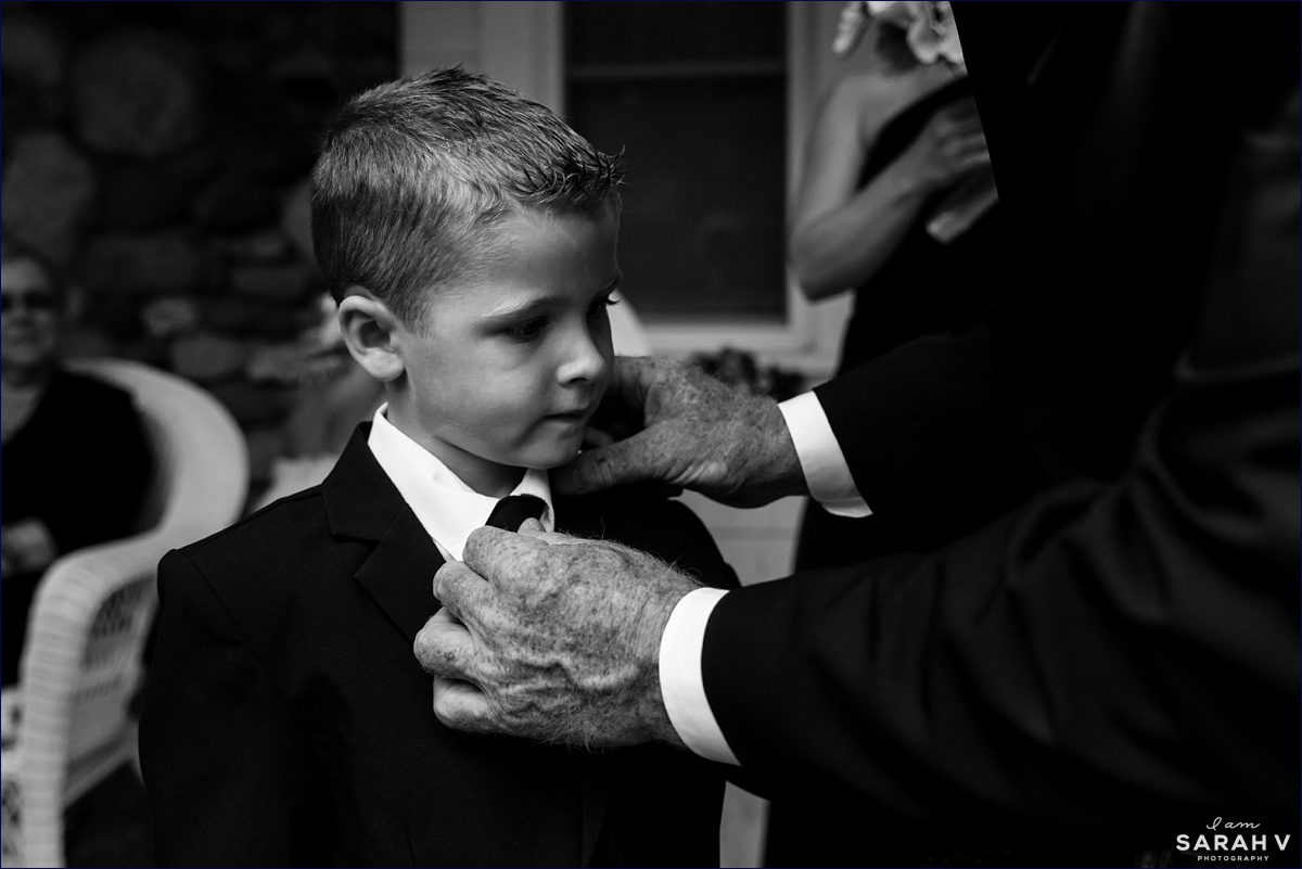 A ring bearer gets his tie straightened by his grandfather on Mount Desert Island Maine