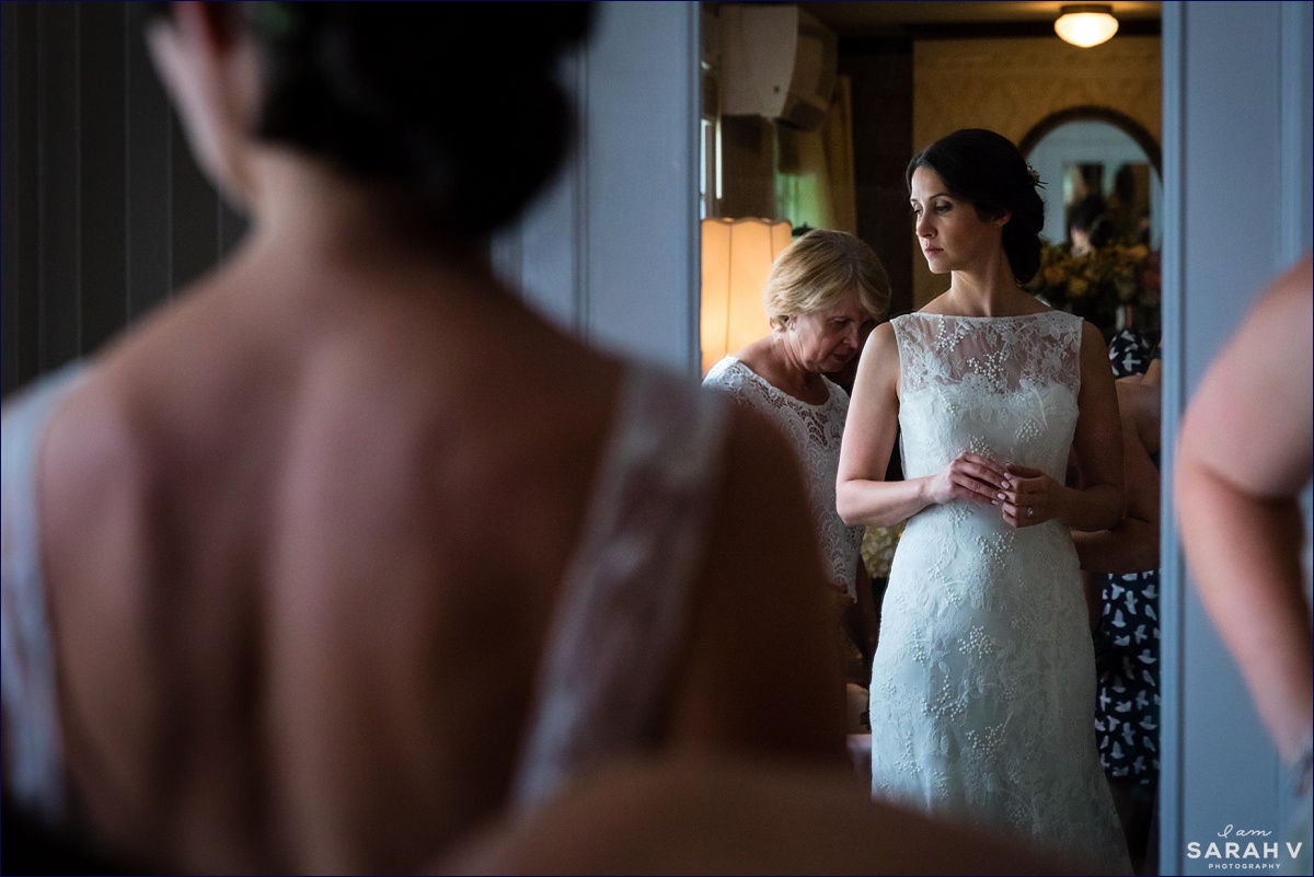 The bride gets into her wedding dress with the help of her mom and sister before her Bar Harbor Wedding