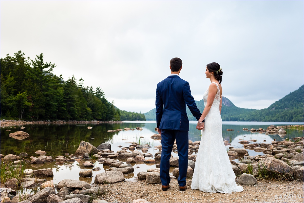 The bride and groom look out over the beautiful Jordan Pond in Acadia