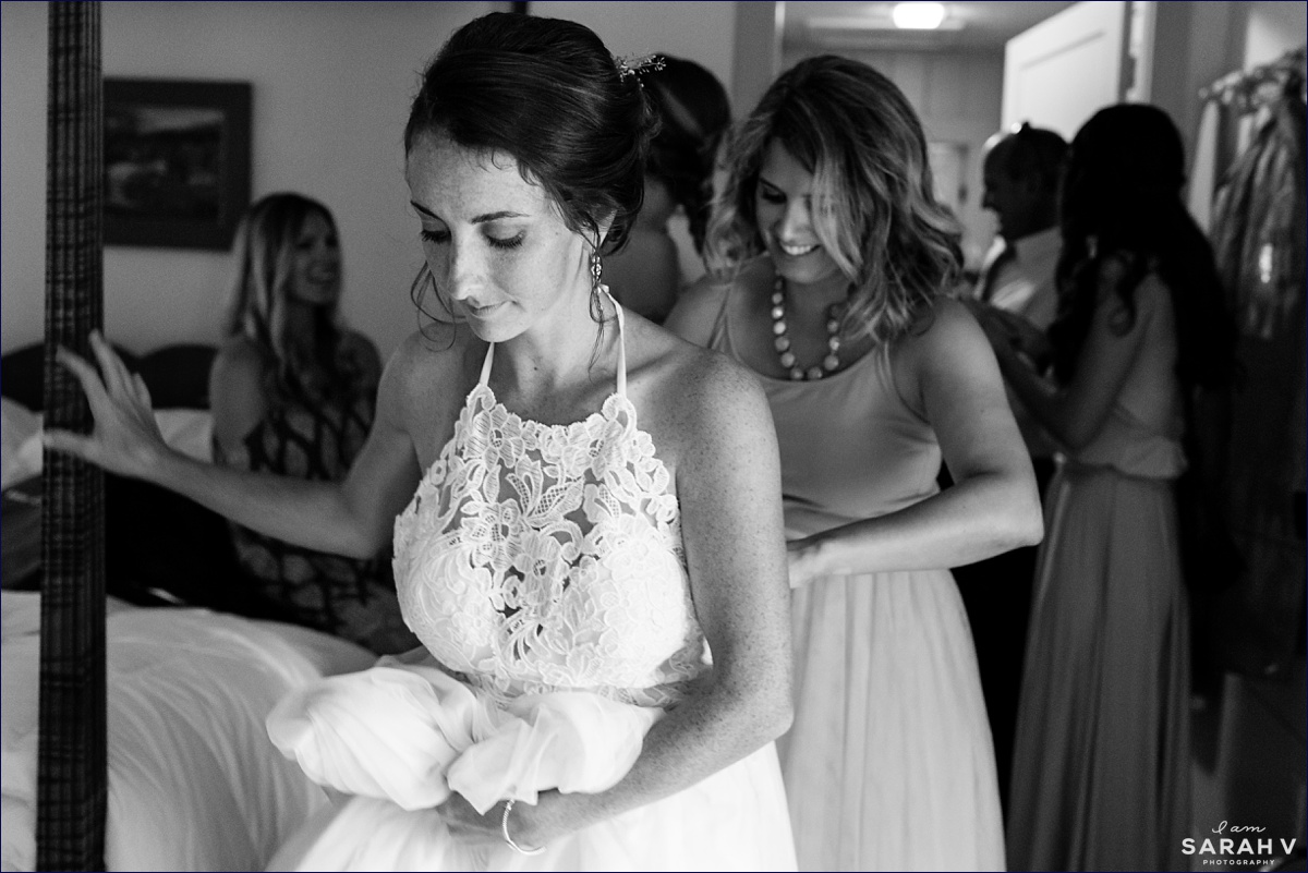 The maid of honor does the final zipping of the bride into the wedding gown