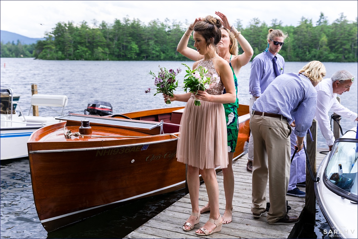 After a windy ride over on a boat to Church Island a guest helps fix the hair of a bridesmaid