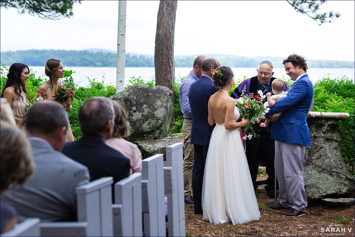The couple stand at the top of the aisle at the outdoor chapel on Church Island NH