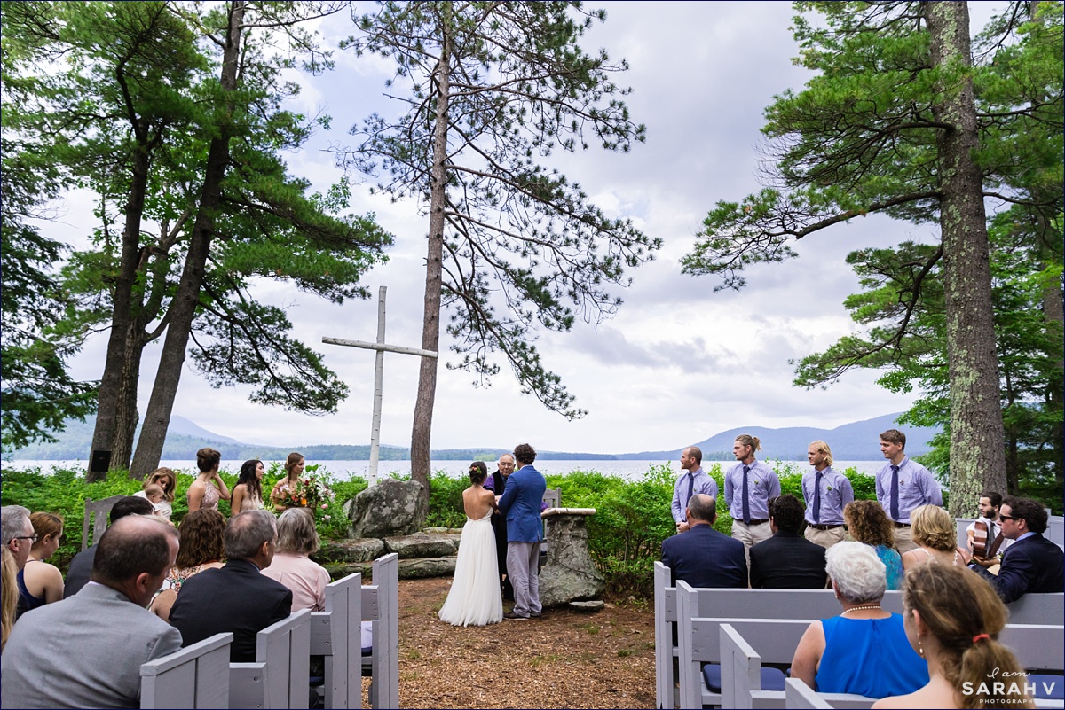 Church Island wedding on Squam Lake NH the outdoor chapel has a beautiful view of the White Mountains and the couple stands right at the water's edge saying their vows