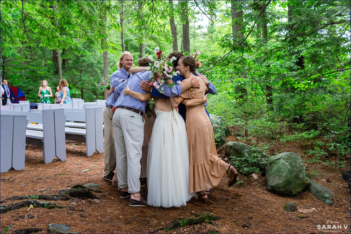 The couple and the wedding party all erupt in celebration after the vows are complete and hug each other at the outdoor chapel on Church Island NH