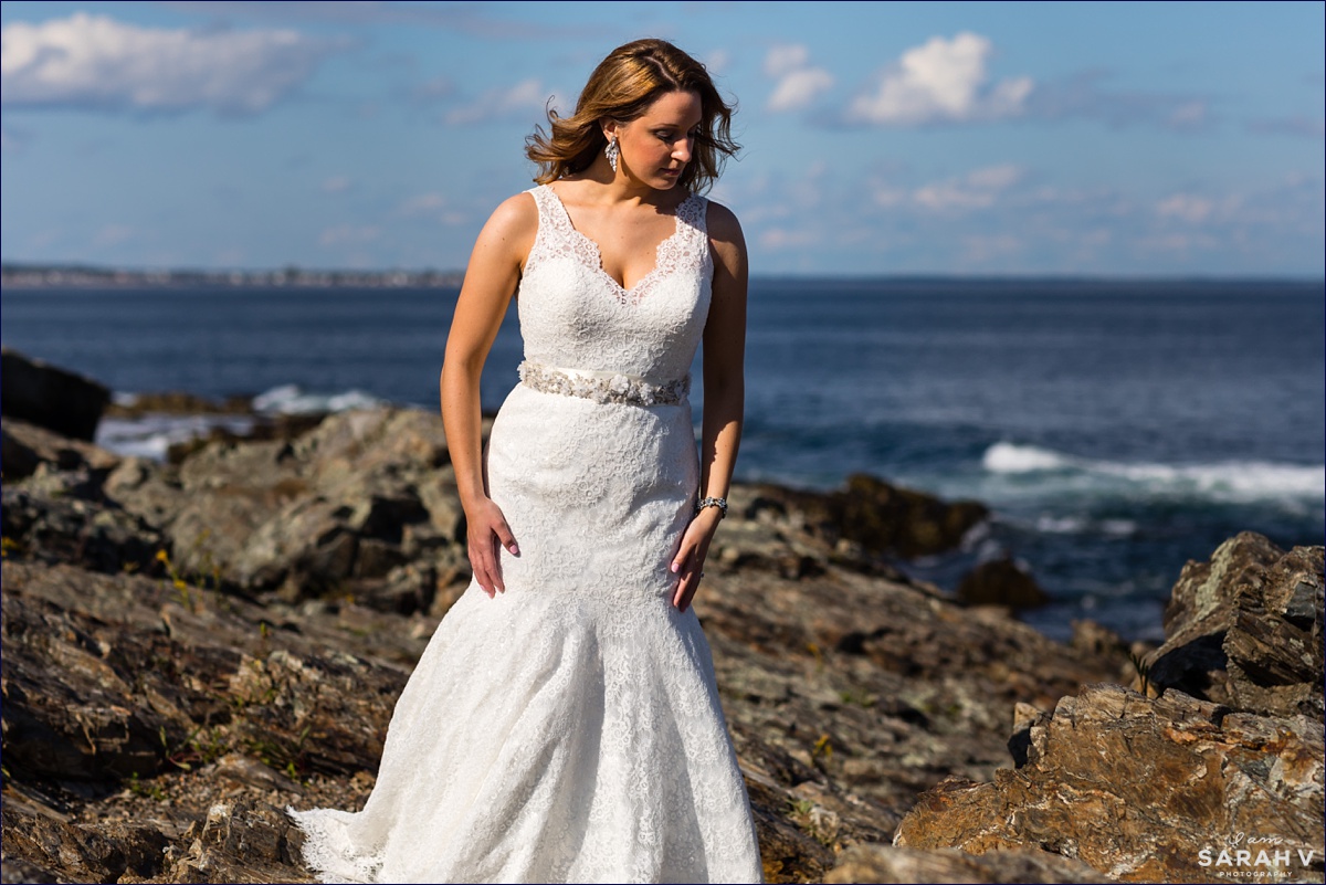 The bride stands out on the rocks before she elopes on a sailboat