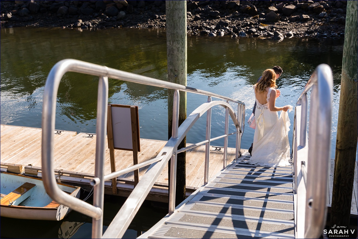 The bride and groom walk down the dock to the sailboat so they can elope on the ocean