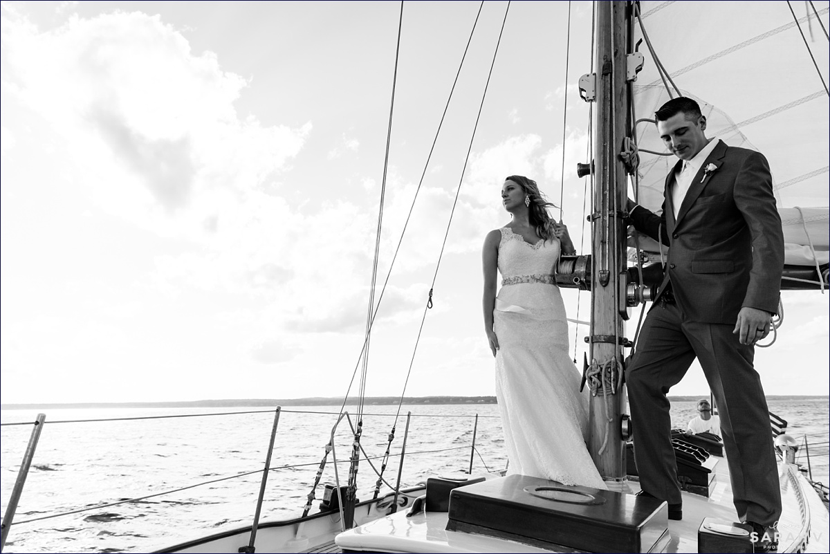 The bride and groom look out over the ocean on the day they eloped on a sailboat