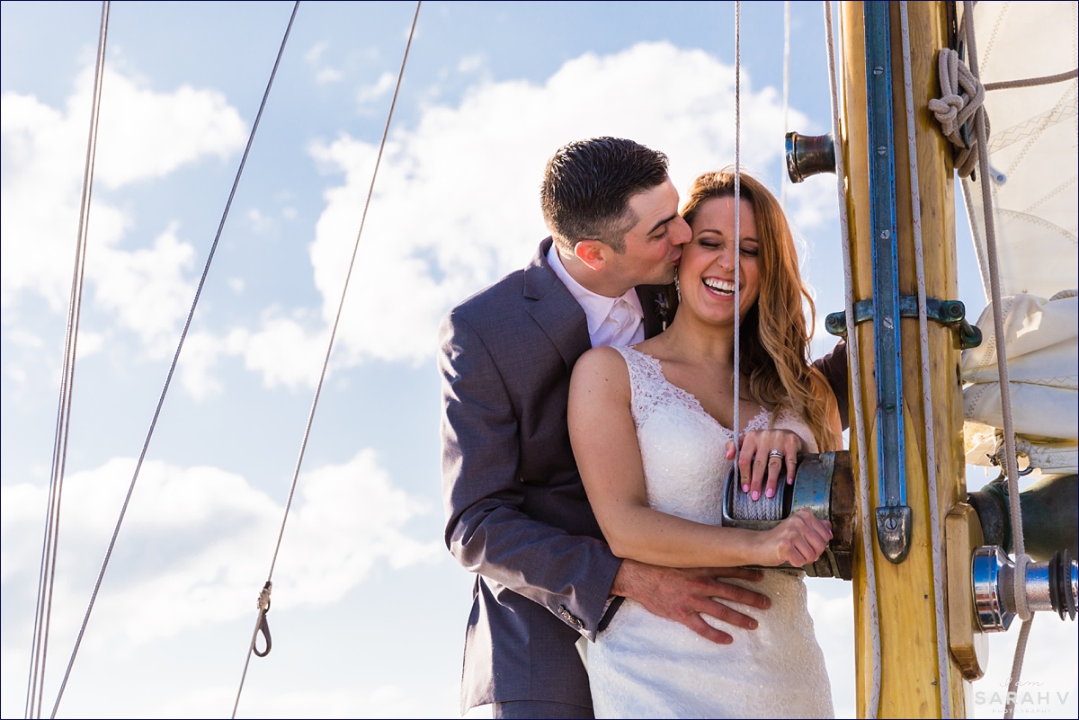 Silverlining Sailing Sailboat Elopement the couple laugh as he kisses her cheek after they had their wedding aboard a boat off the coast of Maine