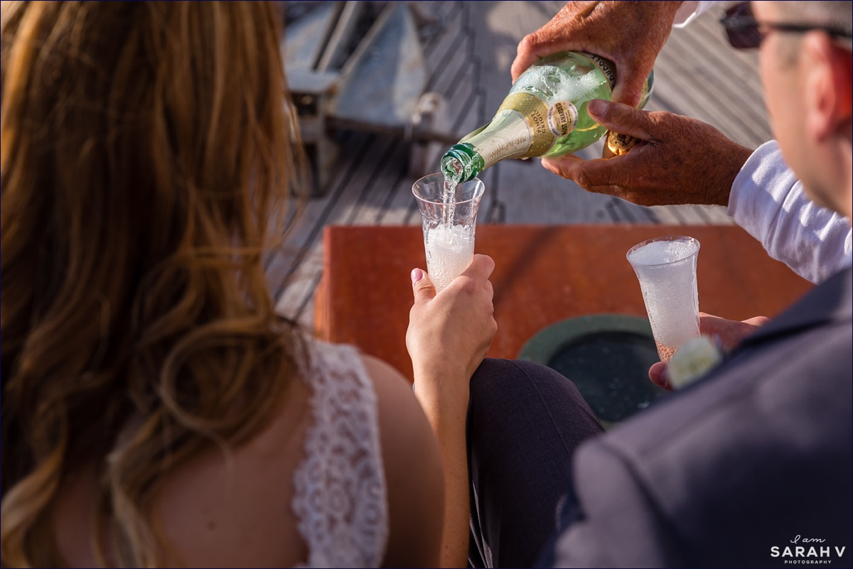 Captain Jack pours champagne for the married couple after they eloped on the Silverlining Sailing sailboat