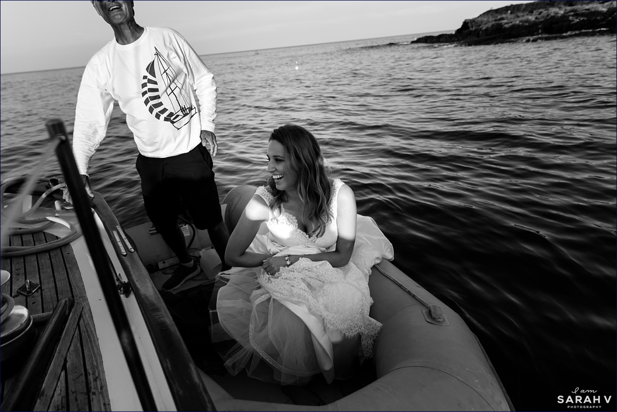 The bride gets into a dinghy to get from the sailboat to the shore of Perkin's Cove Maine at low tide