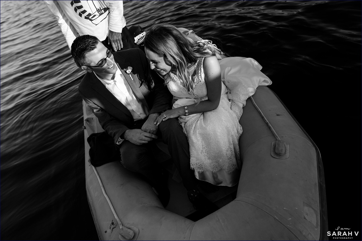 The bride and groom ride a dinghy to the shore of Ogunquit Maine after their wedding on the ocean
