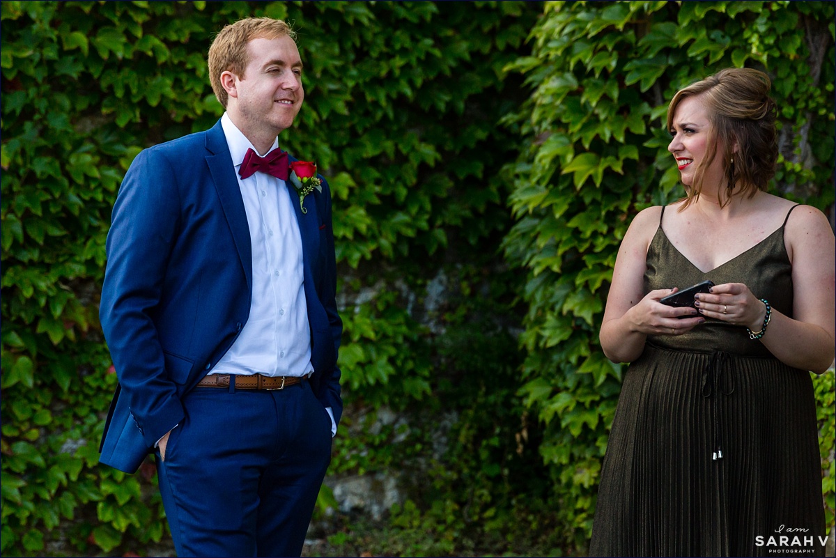 The groom and his sister await the start of the wedding in front of an ivy wall