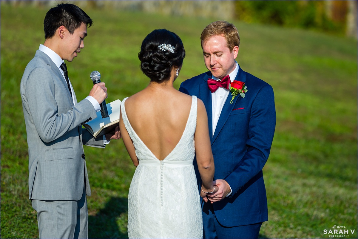The groom bows his head during the outdoor sunny ceremony in Ipswich MA