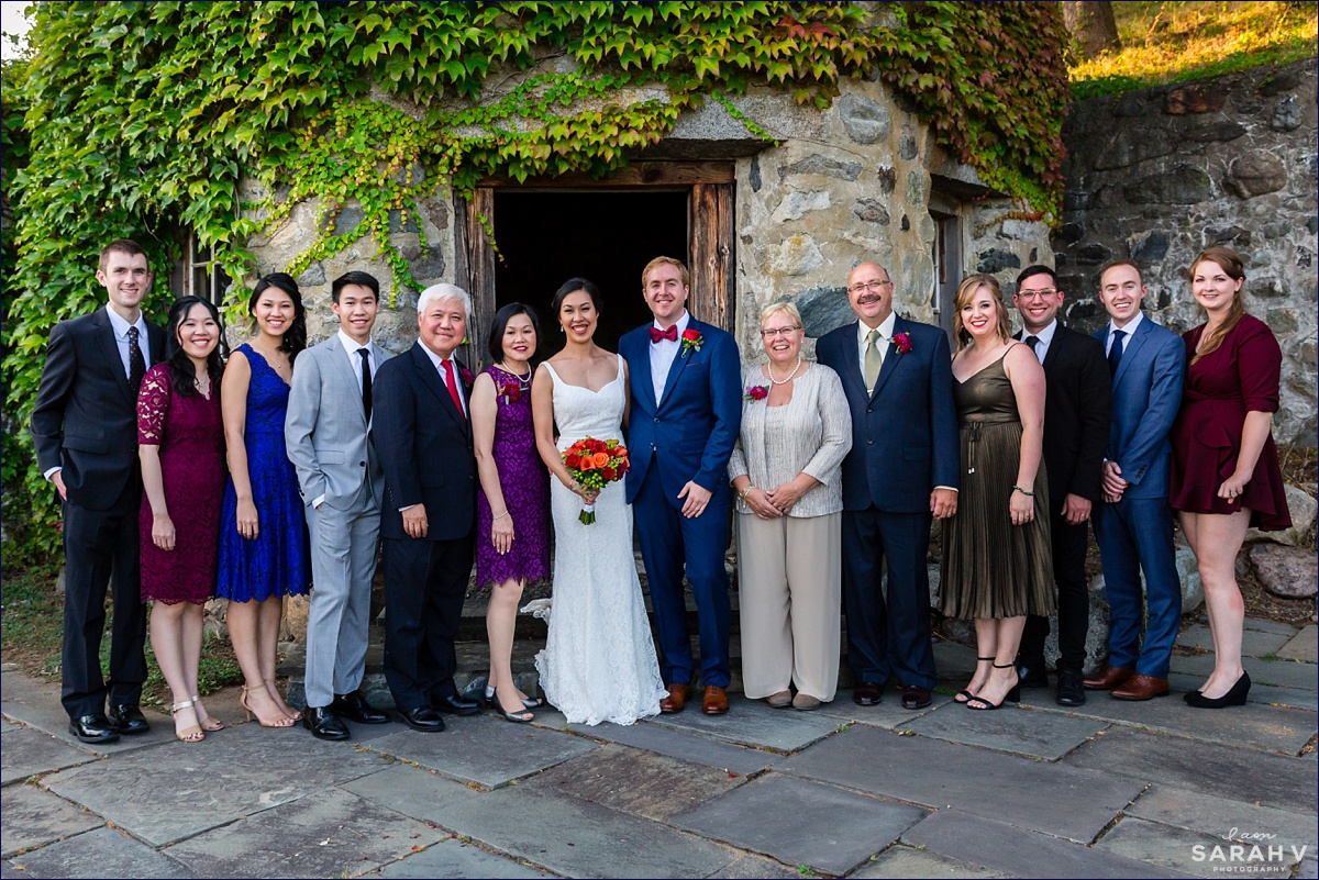 The Barn at Crane Estate wedding the two merged families pose among the ivy and stone pillars
