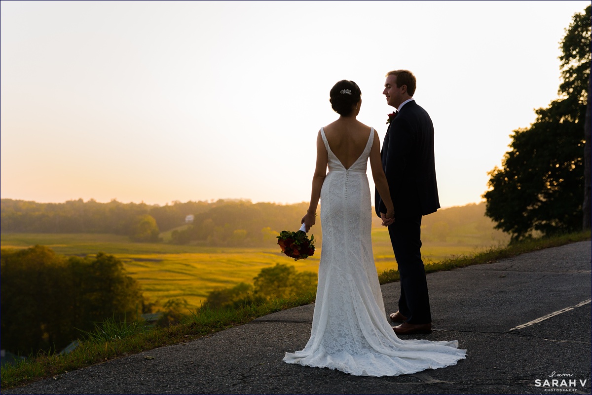 The newlyweds stand up on a hill overlooking the grounds at Crane Estate as the sun starts to set on their wedding day