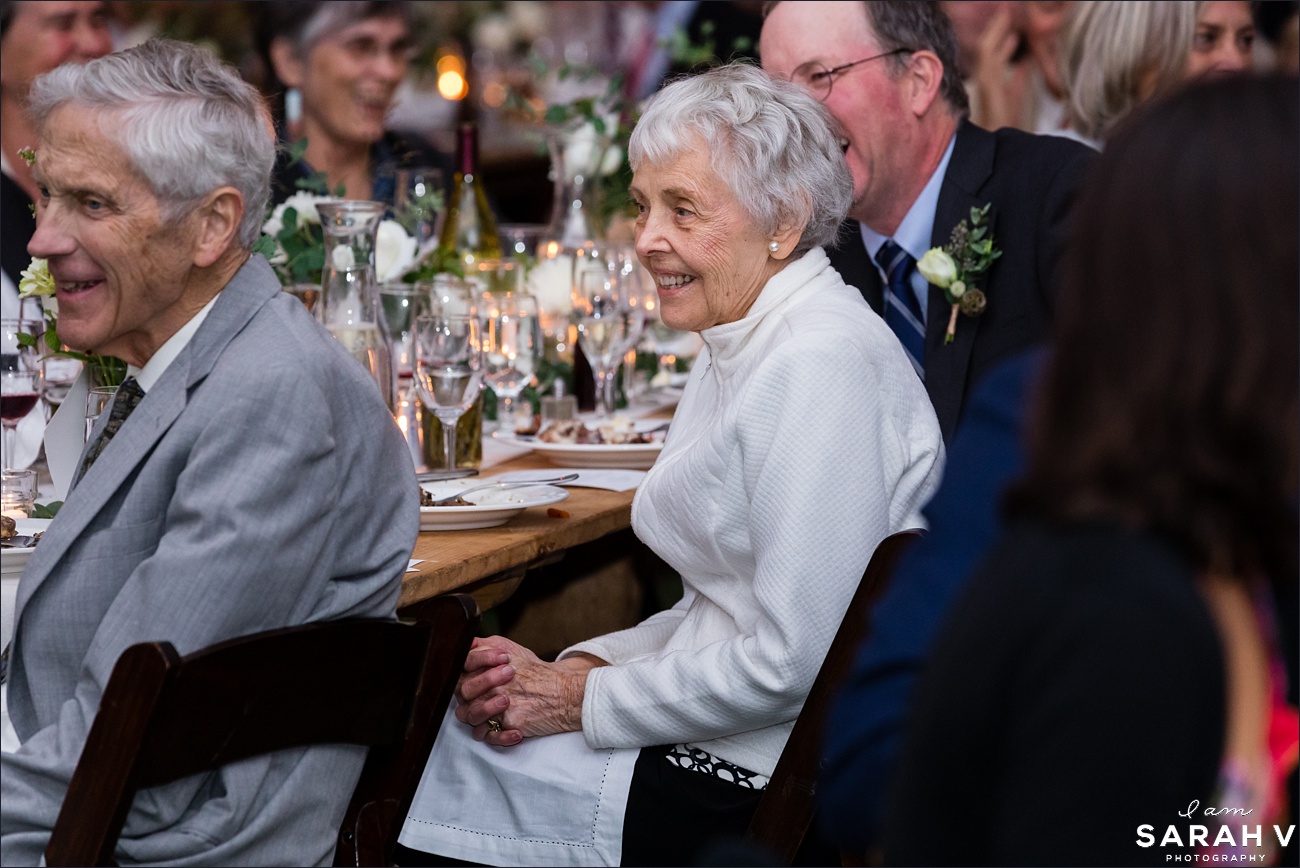The grandmother listens to a toast at the tented wedding reception