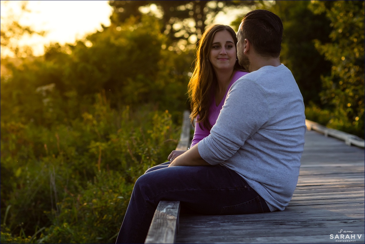 Kettle Cove Maine engagement session she smiles warmly at her soon to be husband as they sit on the wooden walkway