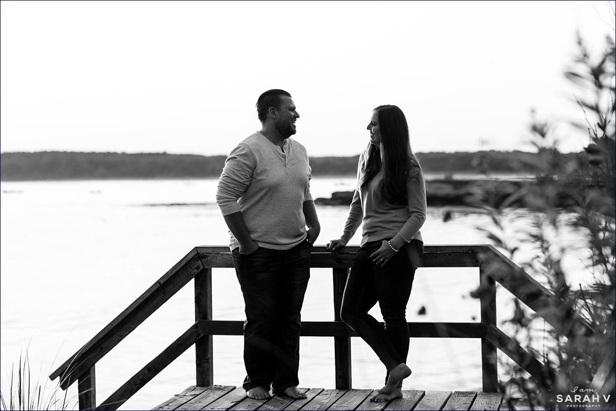 Kettle Cove Maine Wedding the couple stands at the top of a pier smiling as the sun starts to set