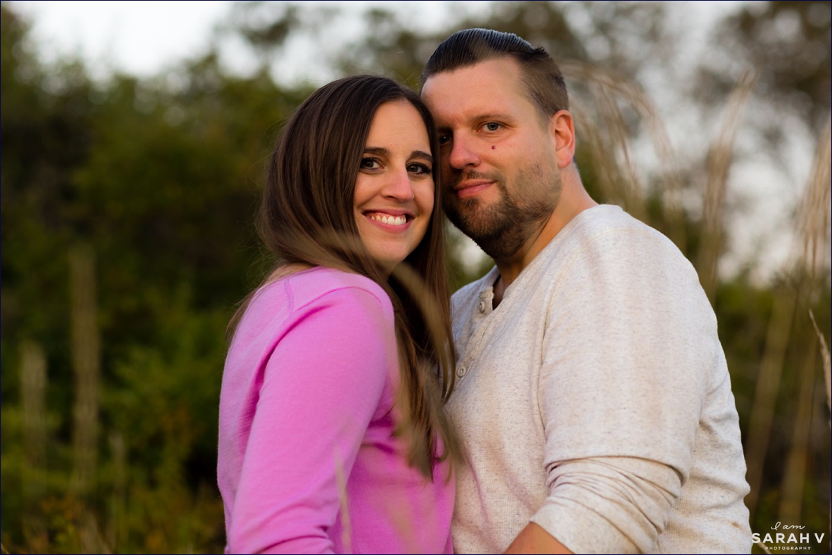 While standing in the tall grass the couple pose for a photo at their Southern Maine engagement session