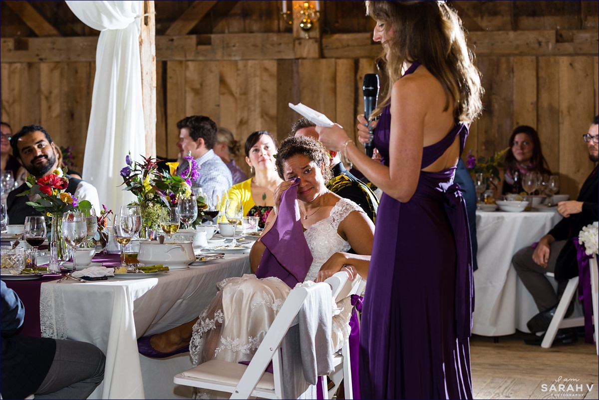 The maid of honor gives a speech at the Maine barn wedding reception and the bride tears up