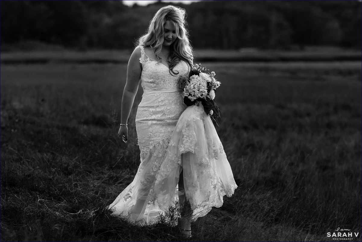 The bride walks out in the sea grass on her wedding day