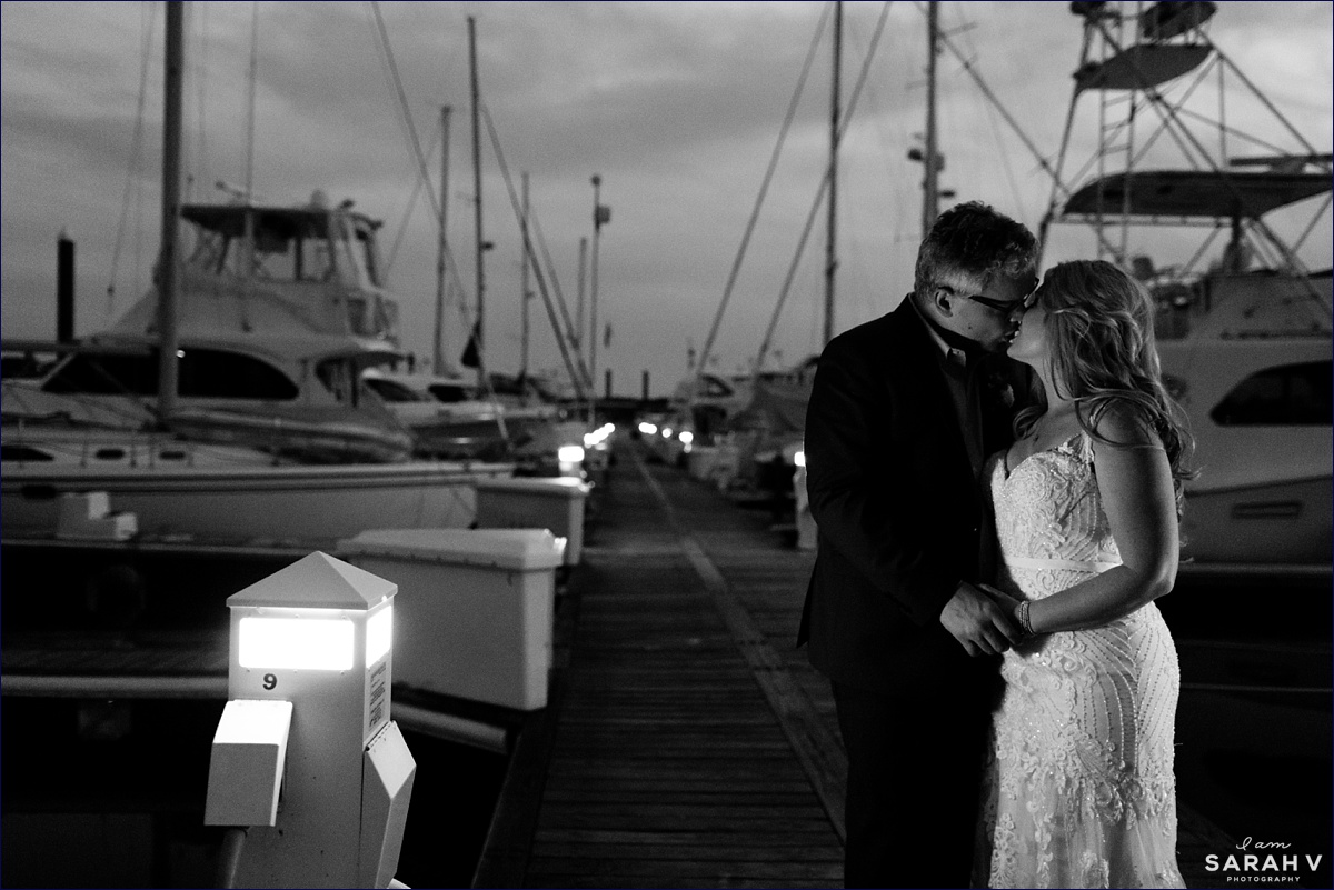 Husband and wife kiss on the docks on the night of their NH elopement