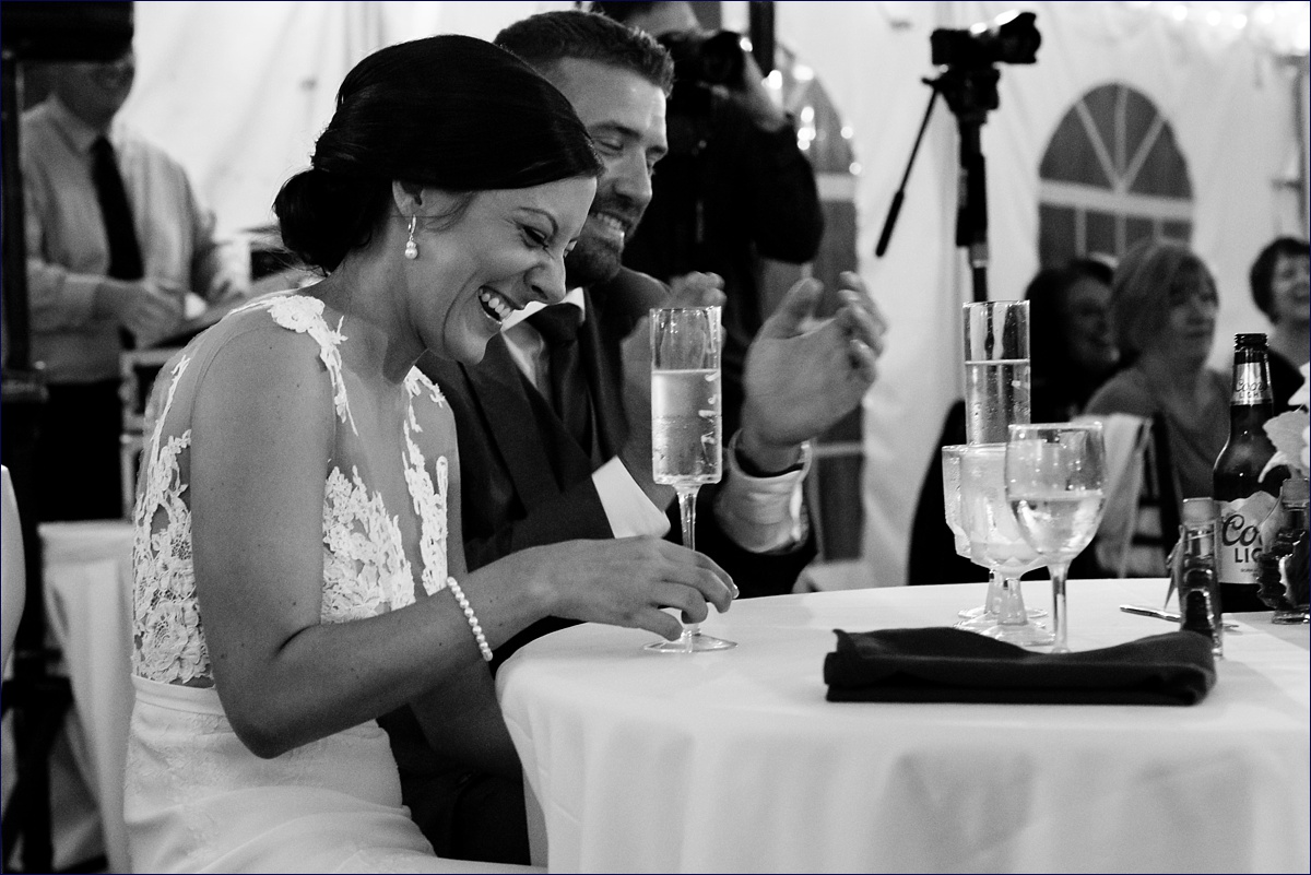Waterville Valley New Hampshire Wedding bride and groom laugh during the toasts at their reception under the tent
