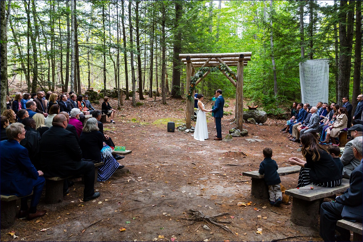 Maine Hardy Farm wedding ceremony in the woods with the bride and groom in front of all of their loved ones
