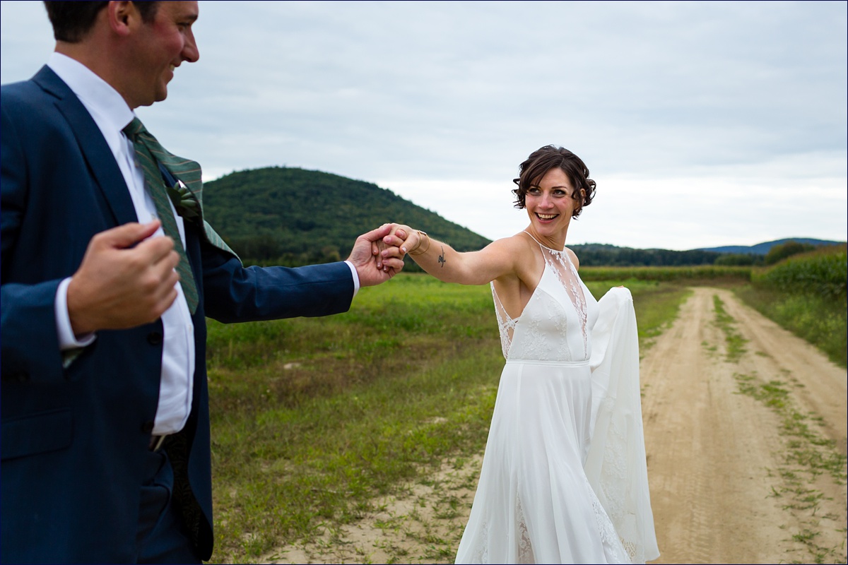 Maine bride and groom dance with one another in front of the white mountains
