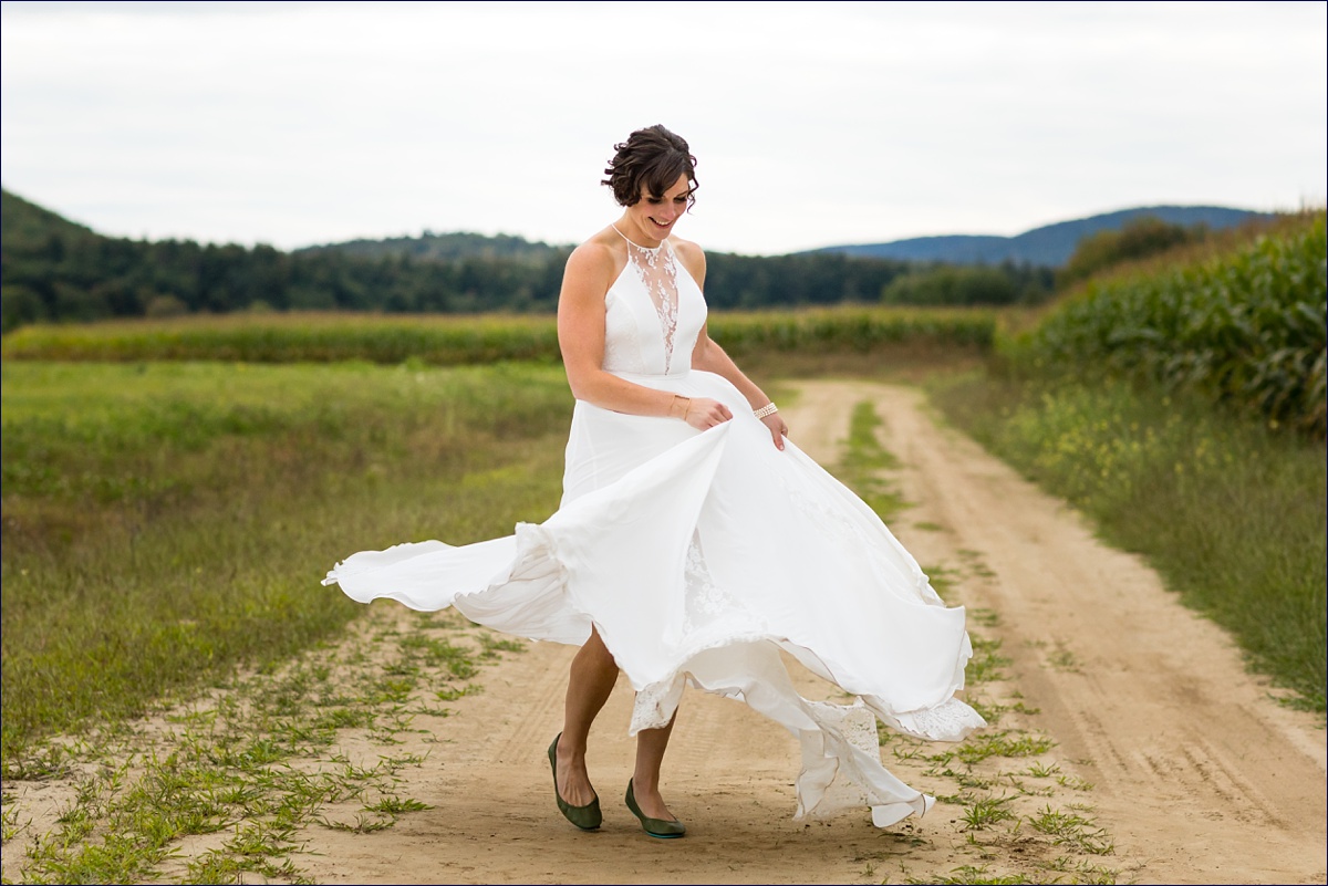 Bride twirling in her gorgeous wedding gown in front of the white mountains of Maine