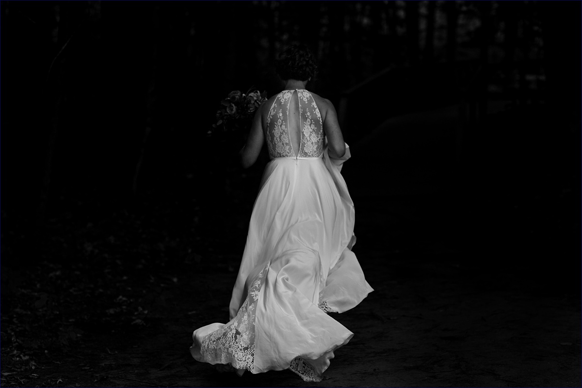 Bride runs off into the woods with her gorgeous lace back wedding gown