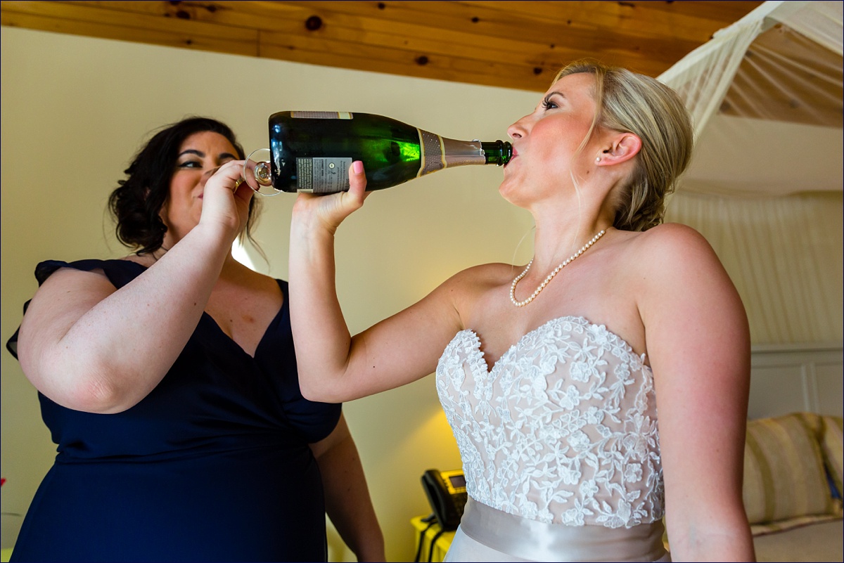 Inn on Peaks Island Maine bride and maid of honor toasting with a bottle of champagne