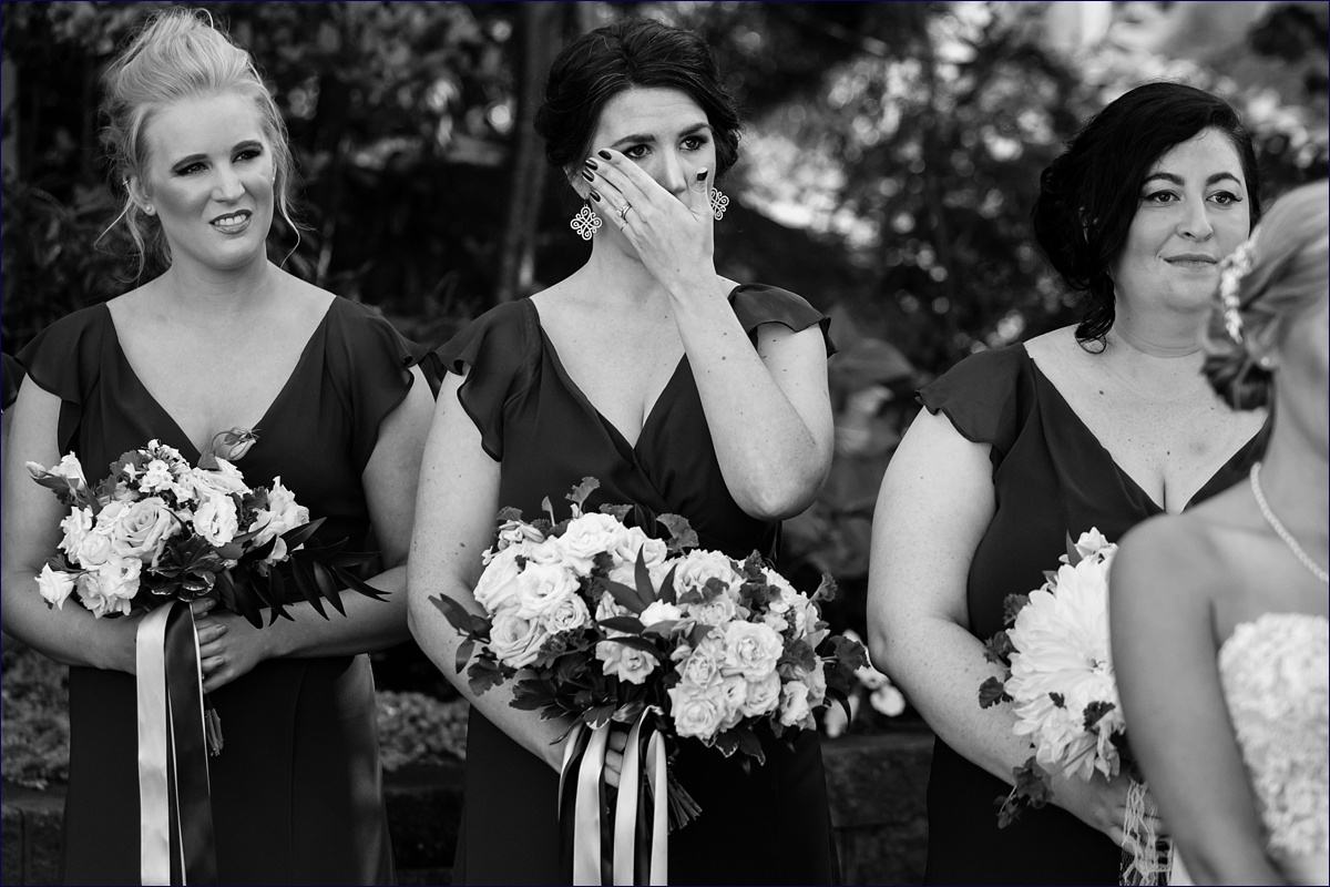 Inn on Peaks Island Maine bridesmaid wiping away a tear during the outdoor ceremony
