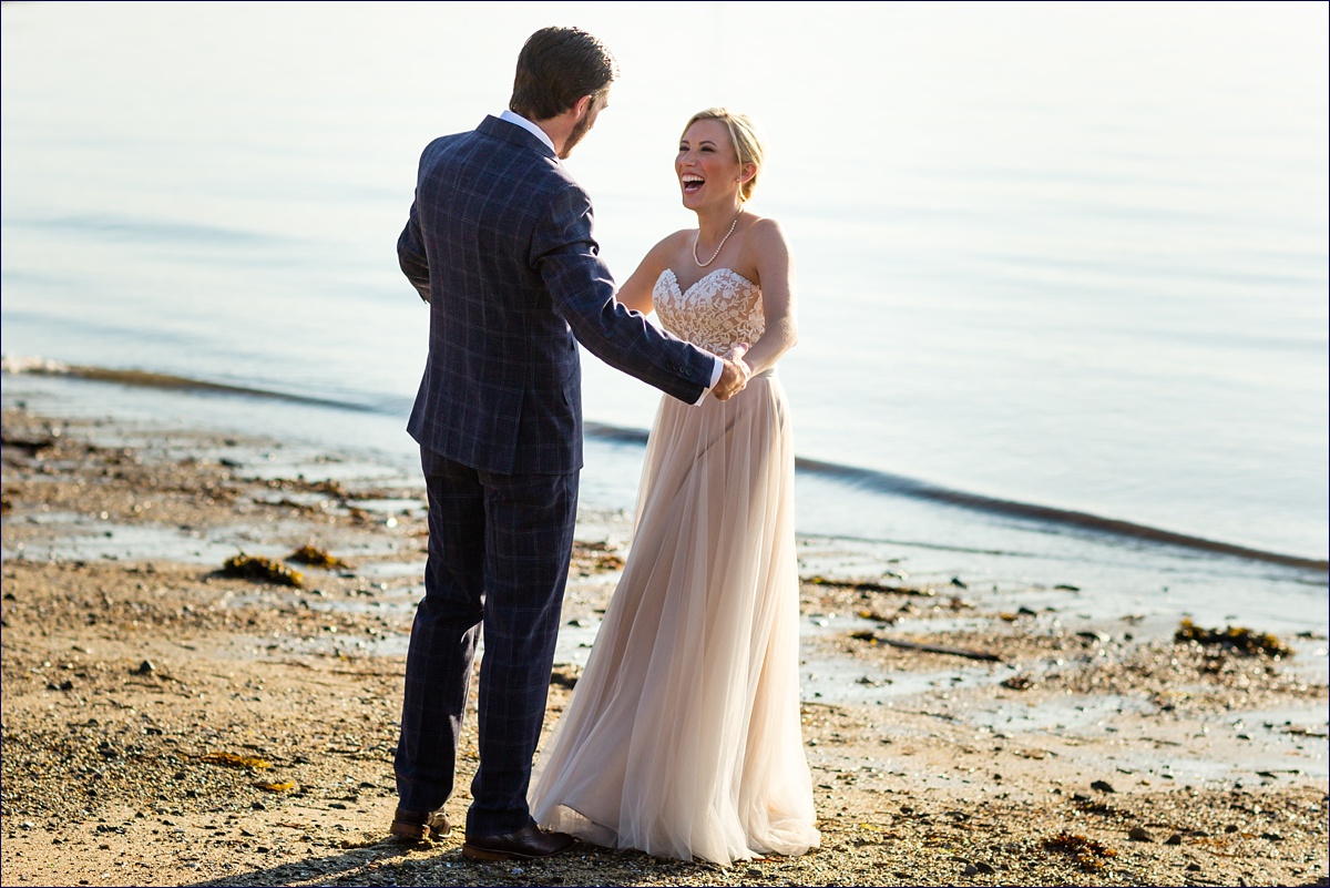 Maine Peaks Island bride and groom playing on the beach together in her off white gown
